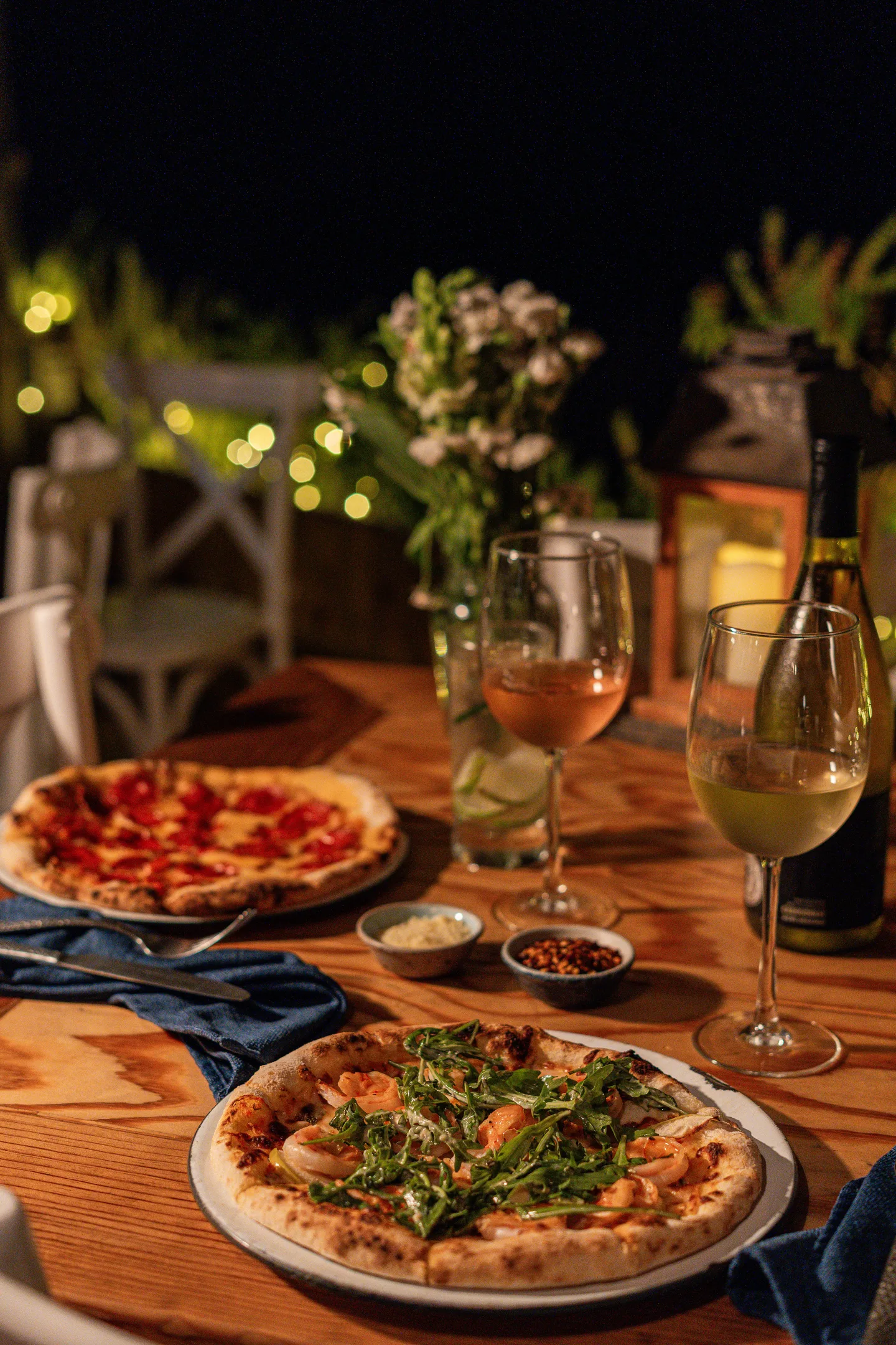 Wood-fired pizzas and wine at a candlelit dinner — NEST Baja