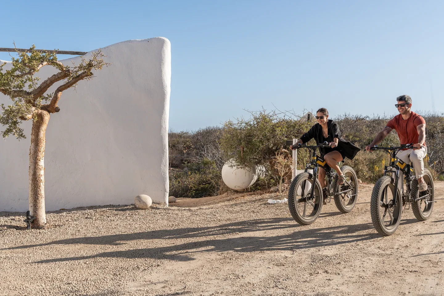 Guests setting off on e-bikes along the desert road — NEST Baja