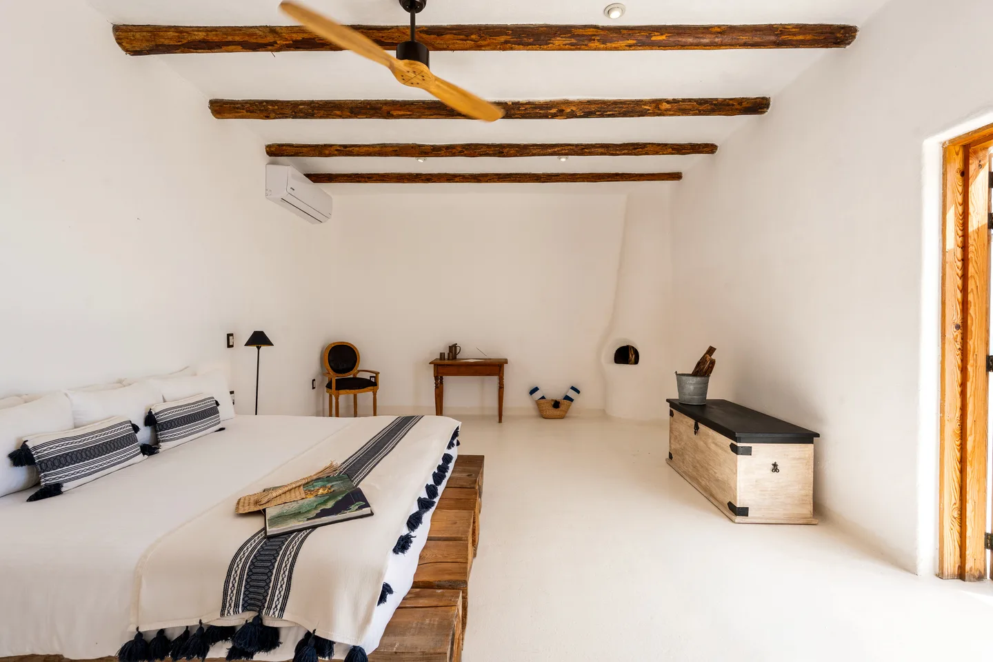 Habitación con escritorio de madera, baúl y chimenea azteca — NEST Baja