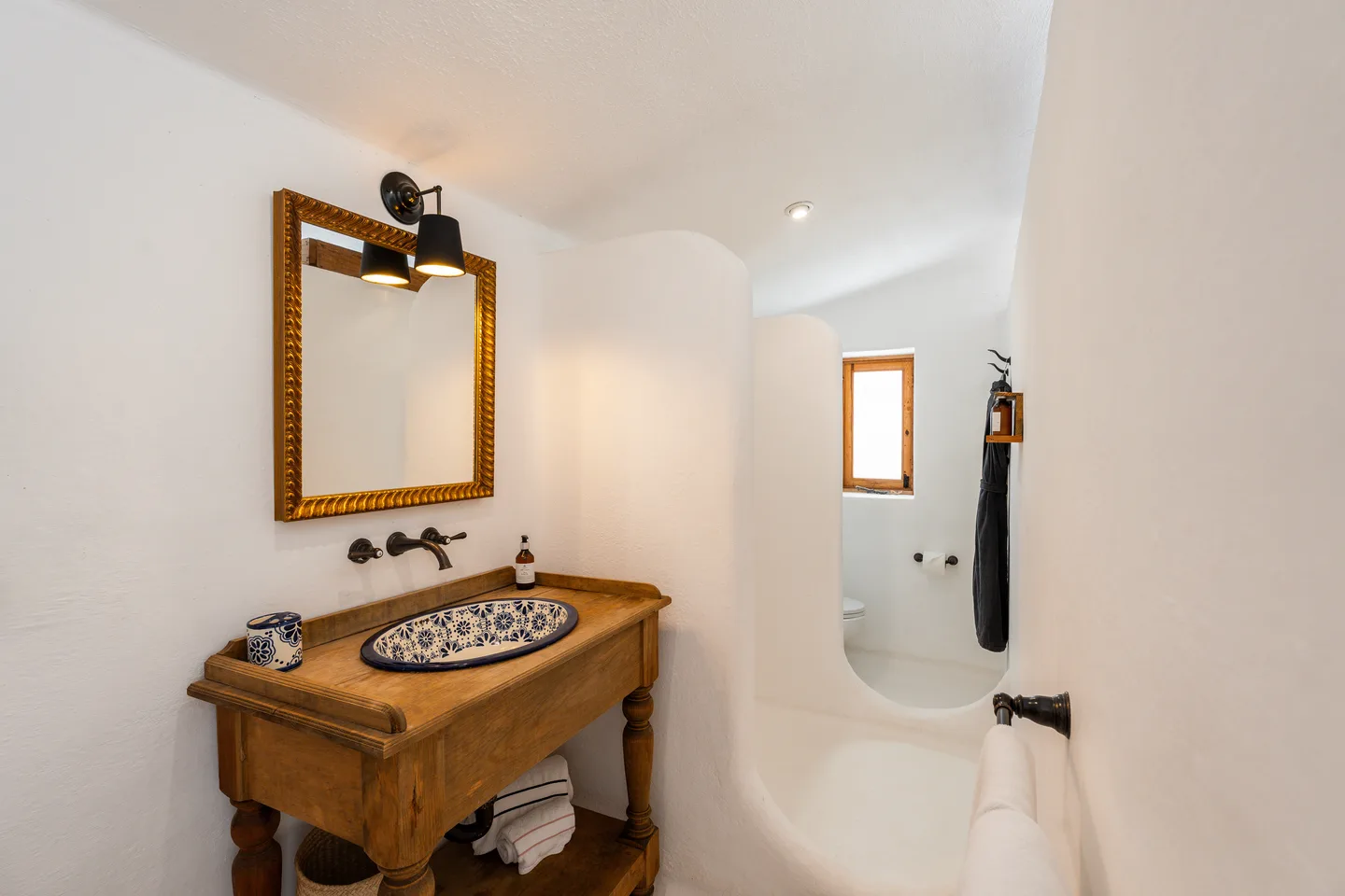 Lavabo de Talavera, espejo dorado y ducha curva a ras de suelo — NEST Baja