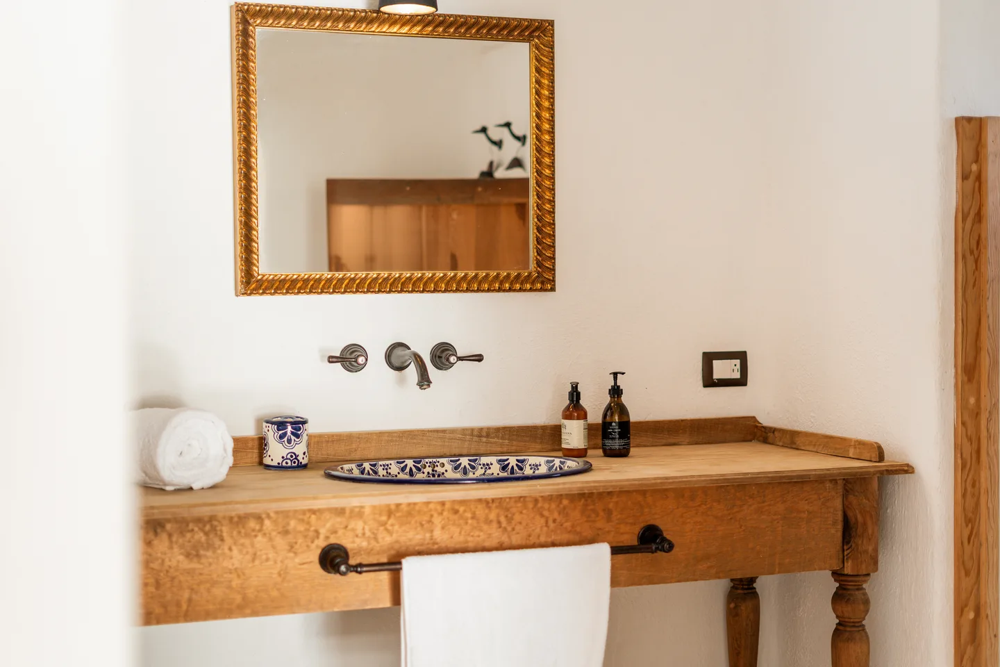 Talavera basin and gilt mirror on a wooden vanity — NEST Baja