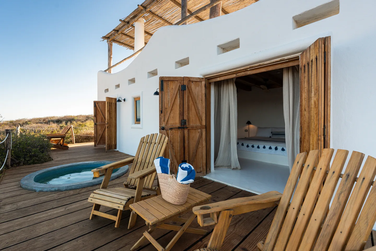 Terraza de la cabaña con alberca privada y sillas Adirondack — NEST Baja